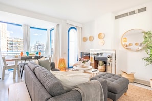 Un salon moderne avec un canapé, une table à manger et une cheminée.