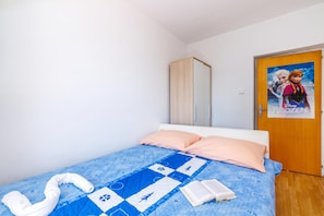 A bedroom with a bed, a quilt, a towel, and a book. - Beachside Apartment Krk, Krk, Croatia (Krk)