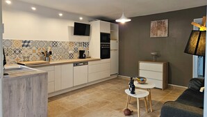 Eine moderne Küche mit Fliesenrückwand, einer Kaffeemaschine und einem eingebauten Backofen.