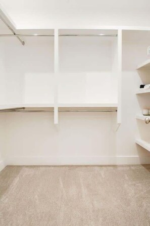 A room with a beige carpet, white walls, and a white wardrobe with open doors. - Rooftop Creative Oasis – Close to Broadway (Nashville)