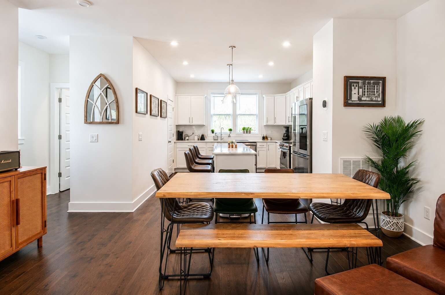 A modern kitchen with white cabinets, a central island, and stainless steel appliances.