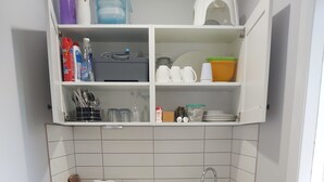 A compact kitchen with a dishwasher, sink, and storage cabinets. - Farm stay Guesthouse (Gnarwarre)