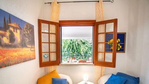Una habitación con dos camas, una mesita y una ventana con cortinas.
