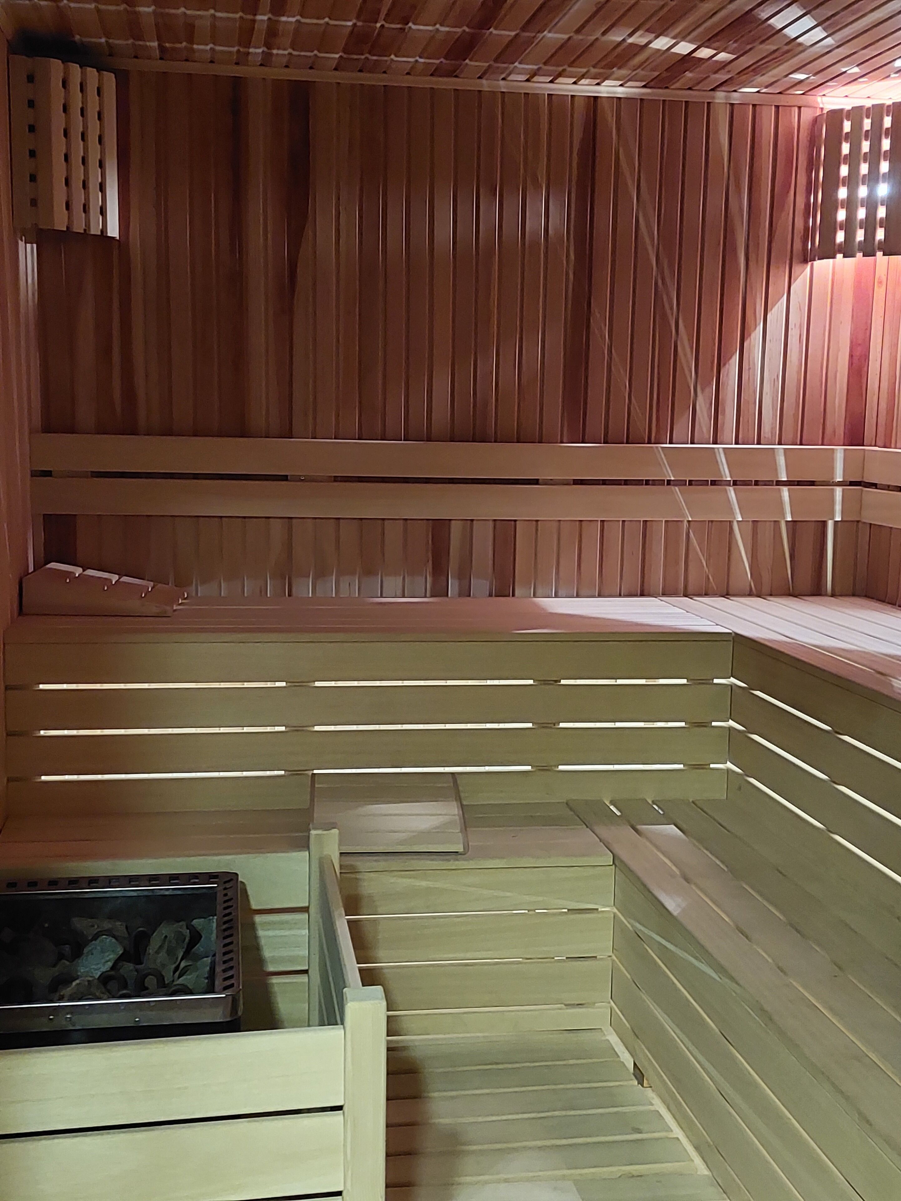 Un sauna avec des bancs en bois et une banquette.