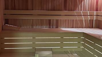 Un sauna avec des bancs en bois et une banquette.