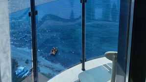 Un balcon offrant une vue dégagée sur la mer et les montagnes lointaines.