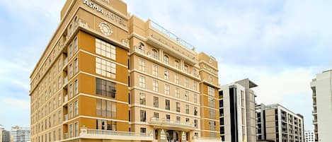 Un ASMA HOTEL de varios pisos con un diseño arquitectónico clásico, que cuenta con una entrada destacada y balcones.