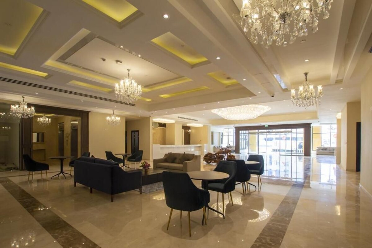 Een ruime lobby met moderne kroonluchters, comfortabele zitplaatsen en een groot raam met uitzicht.