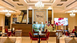 A hotel lobby with a reception desk, a staircase, and seating areas. -  Asma Hotel (Dubai)