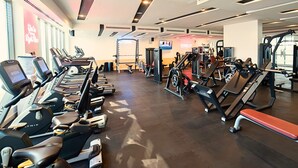 A gym with treadmills, weight machines, and a red bench. -  Asma Hotel (Dubai)