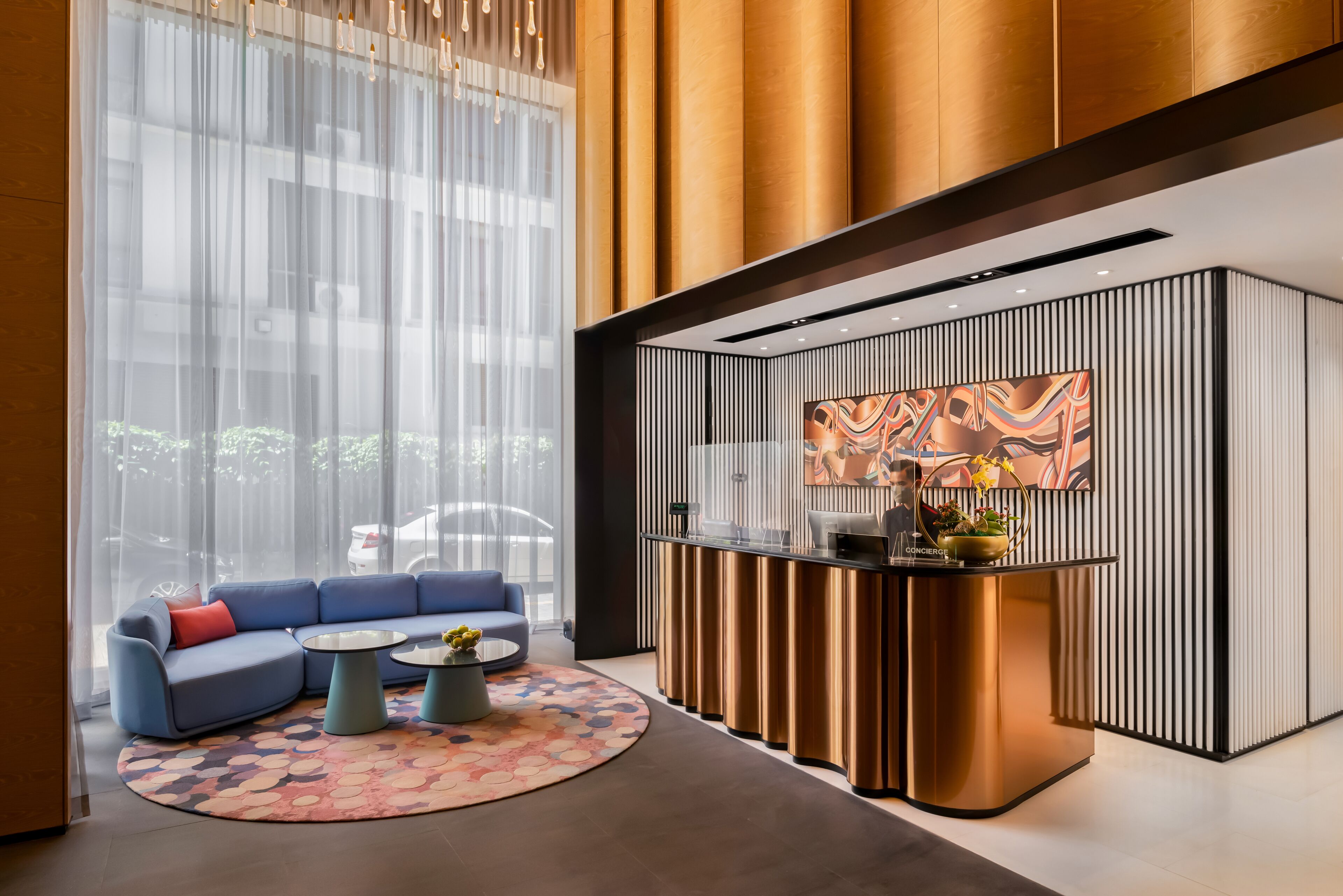 A modern reception area with a blue sofa, a round coffee table, and a decorative rug.