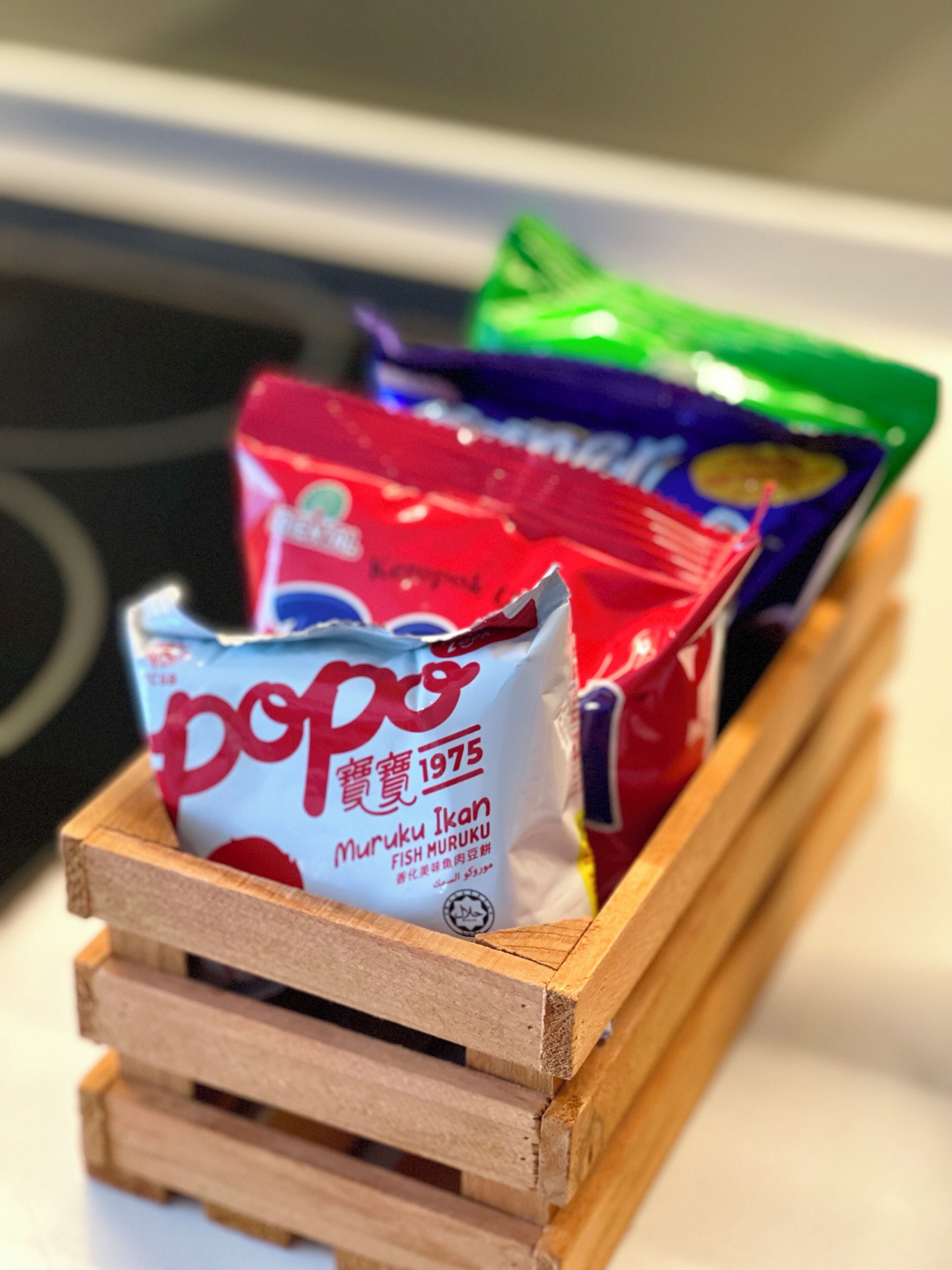 A wooden crate containing several packages of snacks.