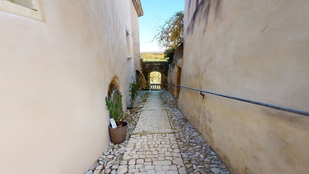 A narrow cobblestone alleyway with stone walls and a metal railing. - Grignan Provencal Tower – Stunning Views & Elegant Stay (Grignan)