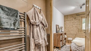 Un baño moderno con un perchero, un mueble de madera y una cama con una cubierta blanca y esponjosa.