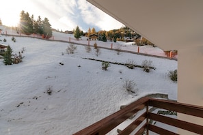 Enjoy breathtaking views from this cozy balcony overlooking a serene snow-covered slope.