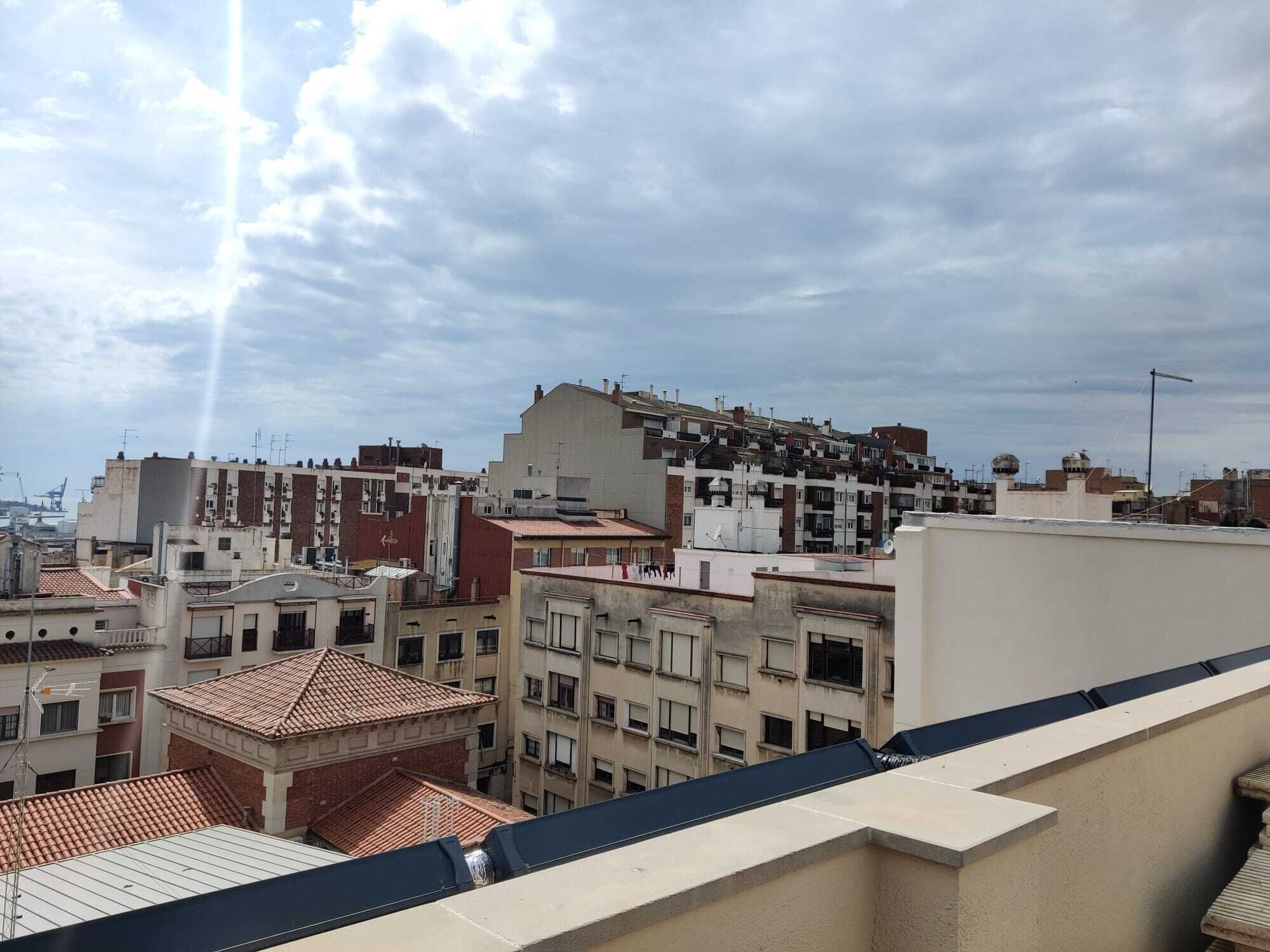 Un paisaje urbano con edificios de varios pisos, algunos con techos planos y otros con techos inclinados.