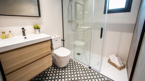 A modern bathroom with a glass-enclosed shower, a white toilet, and a wooden vanity with a mirror. - 1.2 New & stylish flat   Barcelona Touch Apartments (Barcelona)