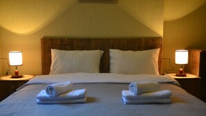 A hotel room with a large bed, two bedside lamps, and neatly folded towels on the bed. - Hotel Tabi (Tbilisi)