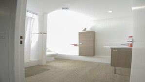 A modern bathroom with a toilet, a wooden cabinet, and a sink.