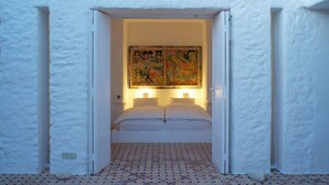 A room with a bed, a large painting on the wall, and a patterned floor. - Unique Architect's House (Ghazoua)