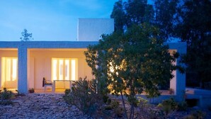 A modern house with two visible rooms, a stone pathway, and surrounding vegetation. - Unique Architect's House (Ghazoua)
