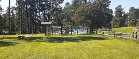 A private property with a fenced area, a small building, and a grassy field.