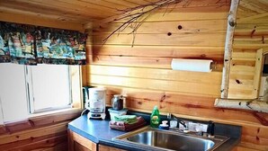 Una cocina compacta con armarios de madera, un lavamanos y un ventanal.