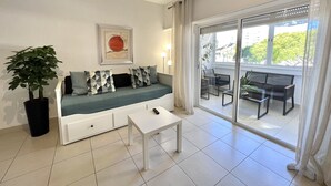 Ein modernes Wohnzimmer mit einer Couch, einem Couchtisch und einer Topfpflanze.