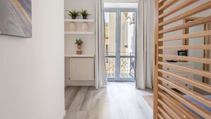 Ein Flur mit einer Holzhakepartition, einem Heizkörper und einer Topfpflanze auf einem Regal.