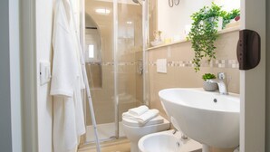 A modern bathroom with a glass shower enclosure, a white sink, and a bidet. - Casa di Luigi ed Ernestina (Dolcedo)