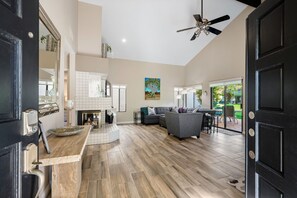 A spacious living area with a fireplace, a sofa, and a dining area.