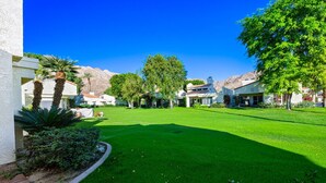 A well-maintained lawn with a clear sky, surrounded by buildings with a Mediterranean architectural style. - Santa Rosa Cove #6 , 3 bedroom 2 bath Condo! (La Quinta)
