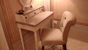A vanity with a mirror, a small stool, and a light fixture. - Lo Strullo Minisuite (Pisa)