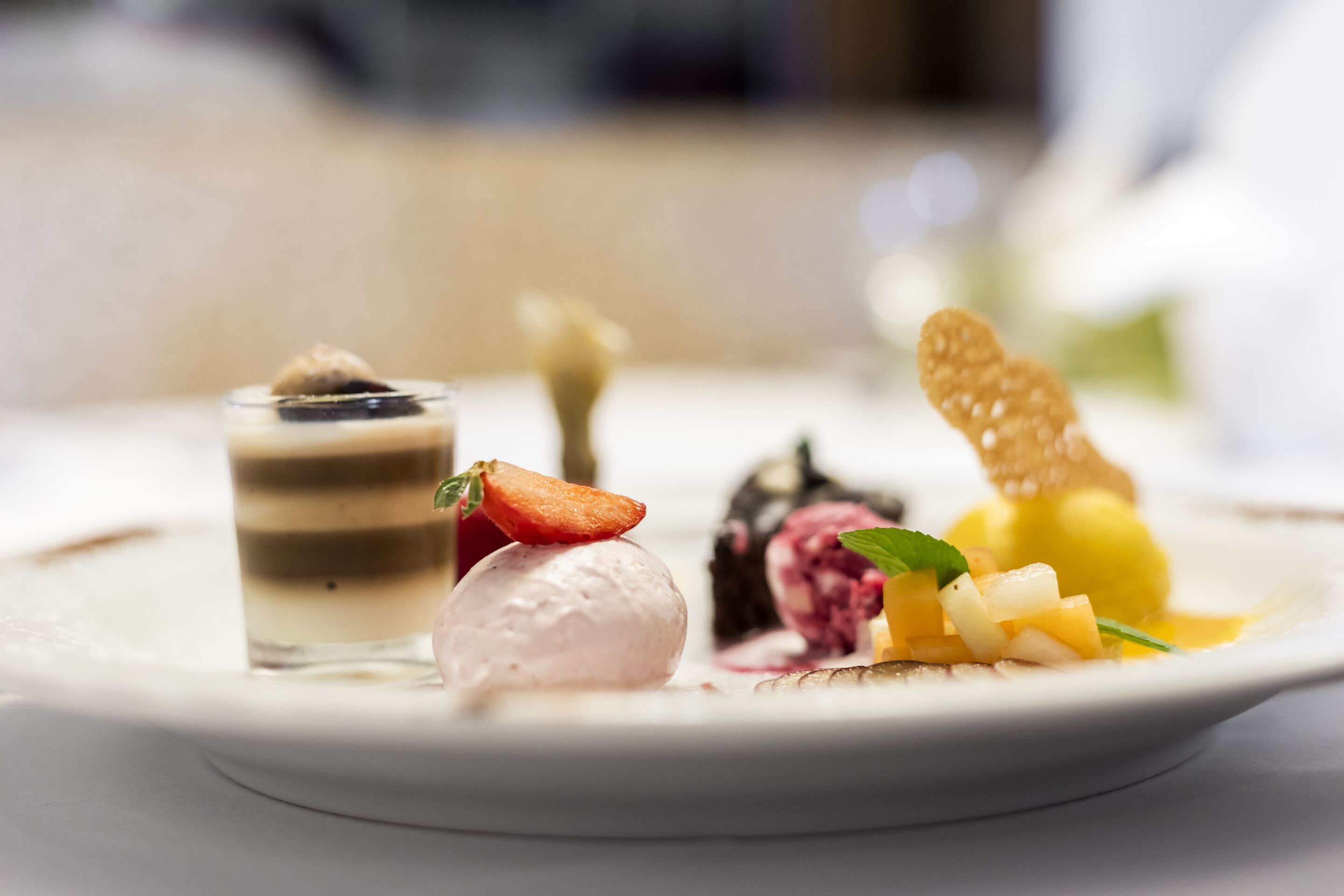 Un plato de postre con distintos helados y frutas.