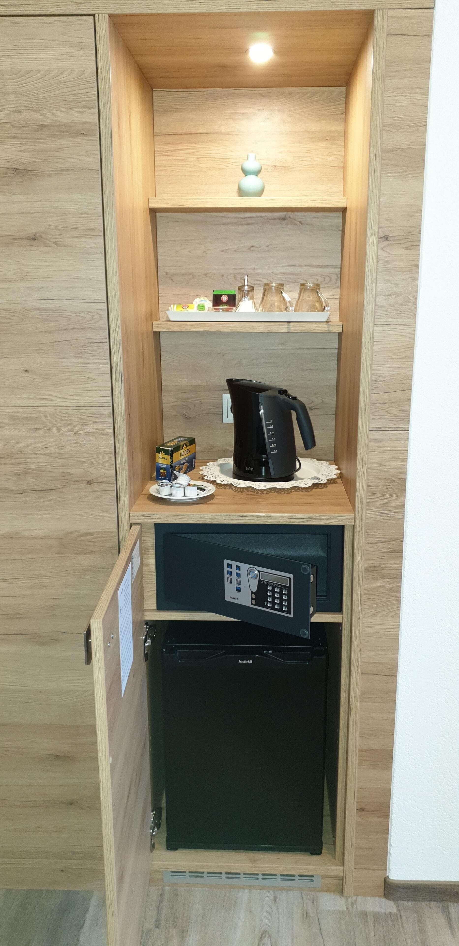 A compact kitchenette with a coffee maker, a microwave, and a small refrigerator.