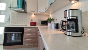 Eine moderne Küche mit Einbauofen, Kaffeemaschine und Toaster.