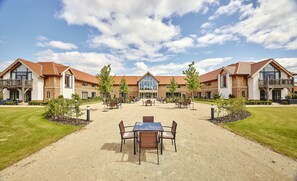 A hotel with a central courtyard, outdoor seating, and a large entrance. - Sandburn Hall Hotel (York)