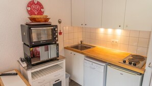 A compact kitchen with a microwave, a small sink, and a dishwasher. - 100m from ski slopes, 5th floor, view ski slopes, balcony, tv, ski locker, 19m², Les Orres (Les Orres)