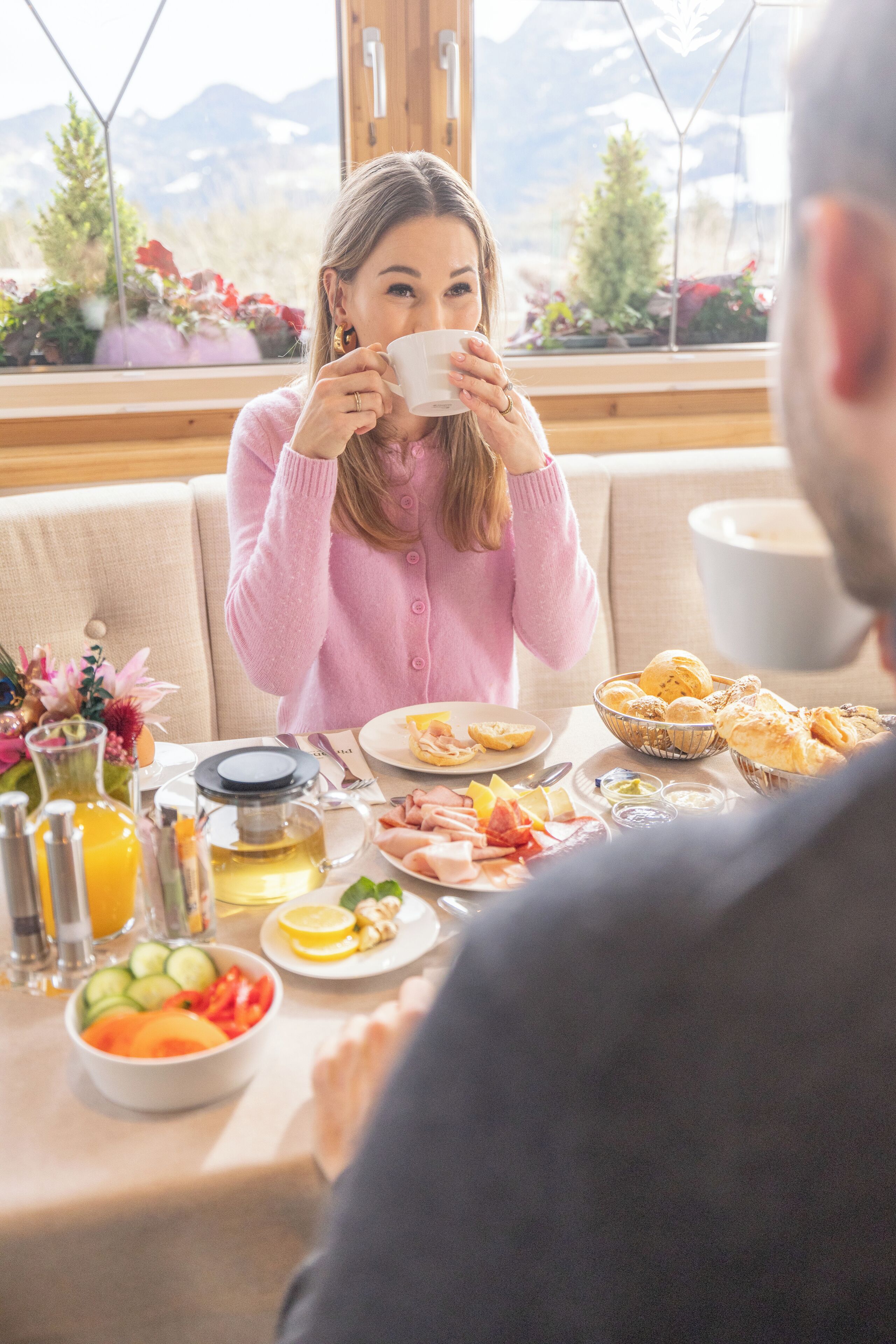 Ein Frühstückstisch für zwei Personen mit verschiedenen Speisen und Blick auf eine Berglandschaft.