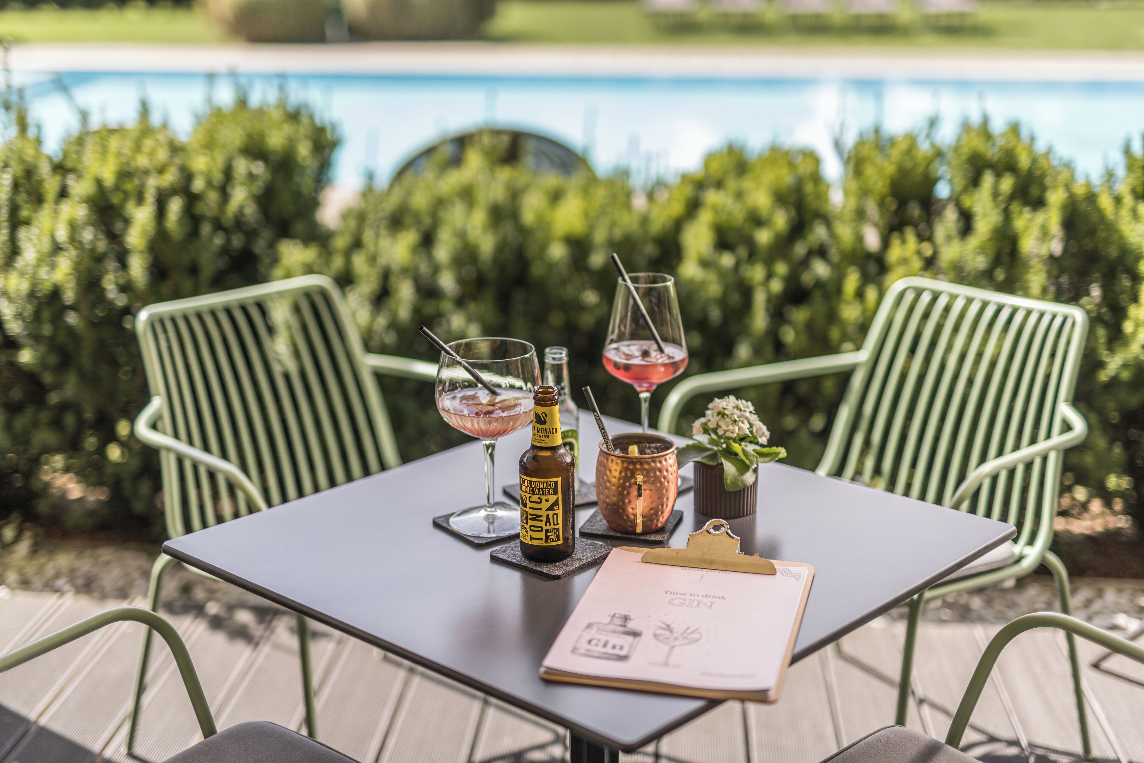 A table with a bottle of wine, two glasses, a menu, and a copper mug.