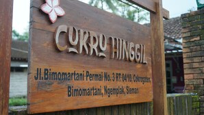 A wooden sign with the name 'CURRUTHINGIL' and address details.