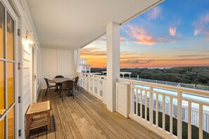 A wooden deck with a table and chairs, a wooden bench, and a white railing overlooking a scenic view. - Gulf and Pool Views with Beach Access (Santa Rosa Beach)
