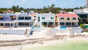 Ein Strandgrundstück mit mehreren Gebäuden, einem Pool und einer Treppe zum Strand.