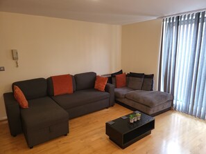 A living room with a sectional sofa, a smaller sofa, and a coffee table.