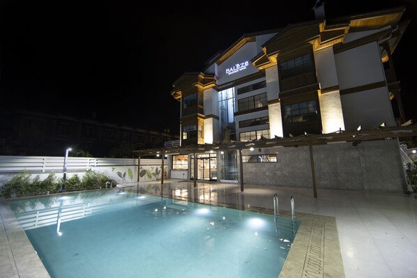 A hotel with a swimming pool, modern architecture, and well-lit exterior. - Balèze Boutique Hotel - Adults Only (Ula)