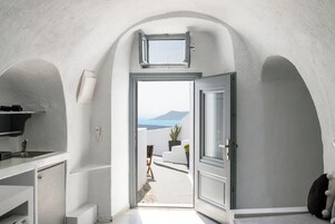 Un pasillo estrecho con vista a un balcón y al mar.