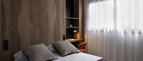 Une chambre à coucher moderne avec un grand lit, un bureau et une chaise.