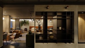 Ein modernes Interieur mit einer Sitzecke, einer Küche und einer dekorativen Pflanzenwand.