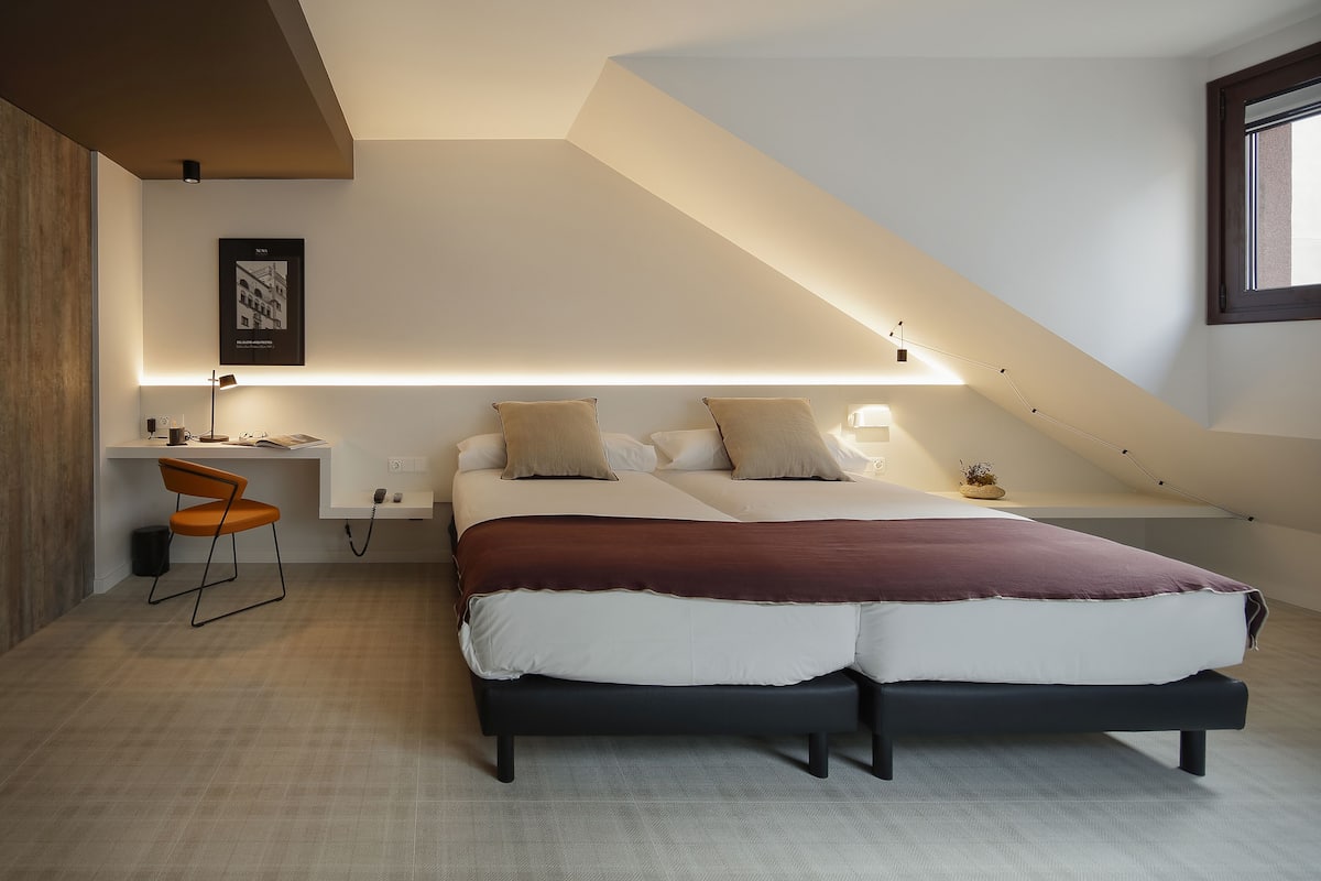 Une chambre à coucher moderne avec un grand lit, un bureau et une chaise.