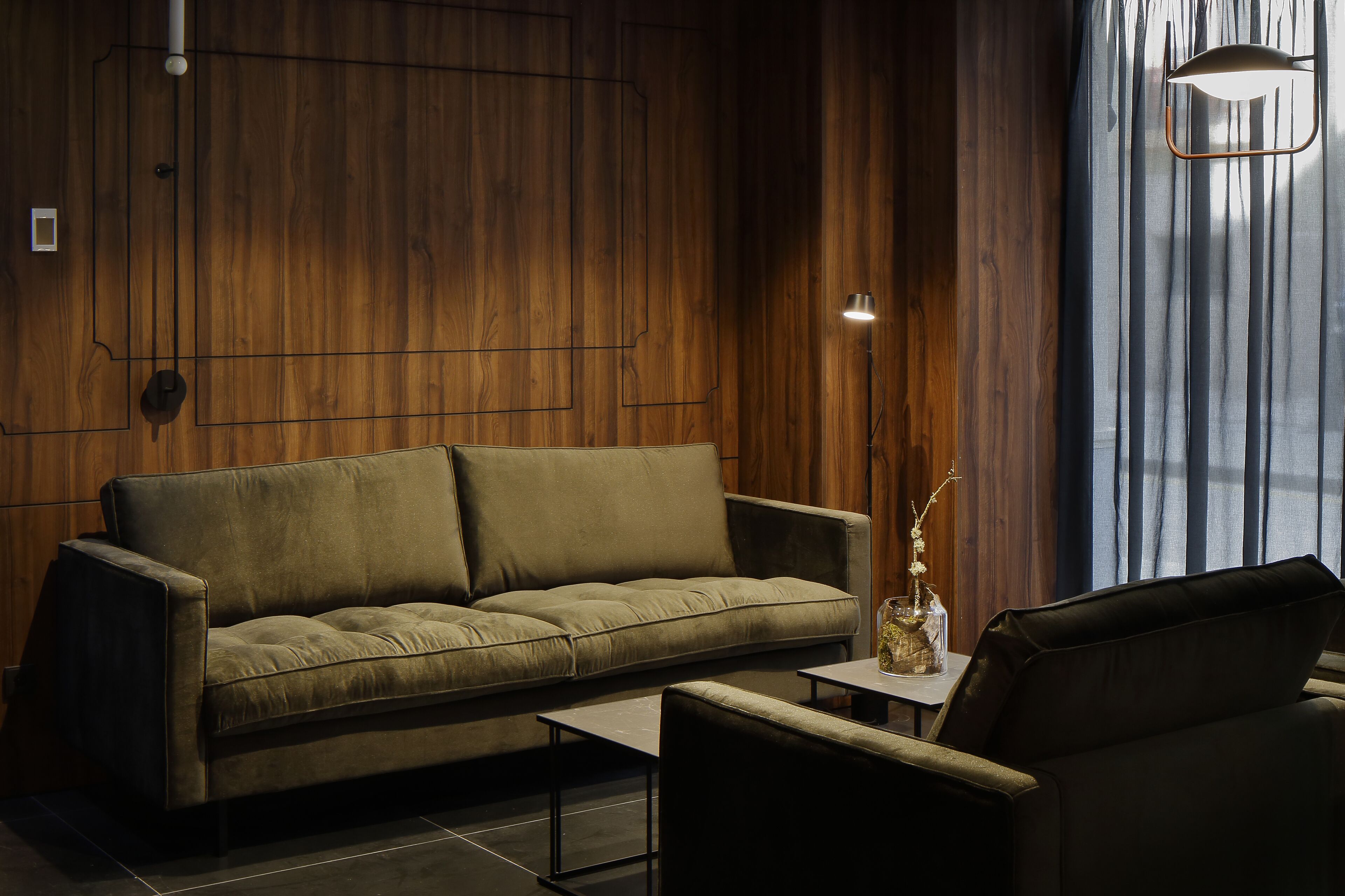 A modern living room with a sofa, a coffee table, and a lamp.